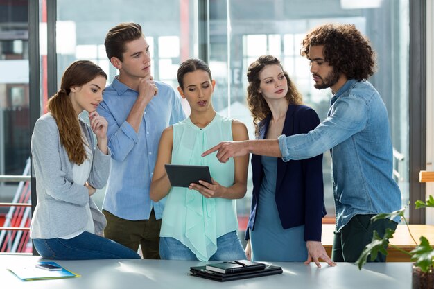 Squadra di affari che discute sopra la compressa digitale nella riunione