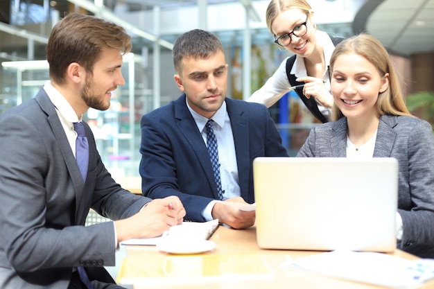 Squadra di affari che lavora al computer portatile per verificare i risultati del loro lavoro.