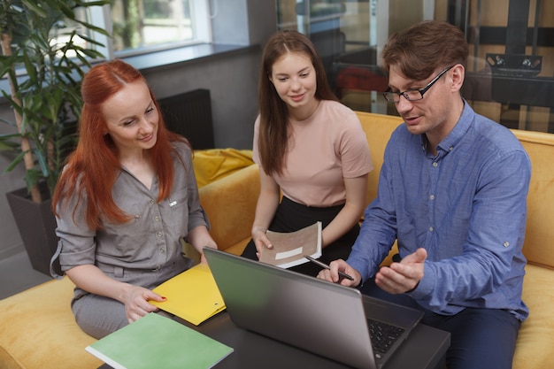 Squadra di affari che utilizza un computer portatile durante la riunione presso l'area di lavoro moderna