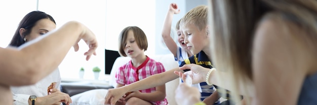 Squadra di bambini gioca contro una squadra di adulti nei giochi da tavolo a casa.