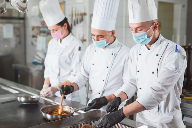 Squadra di cuochi che cucinano in un ristorante