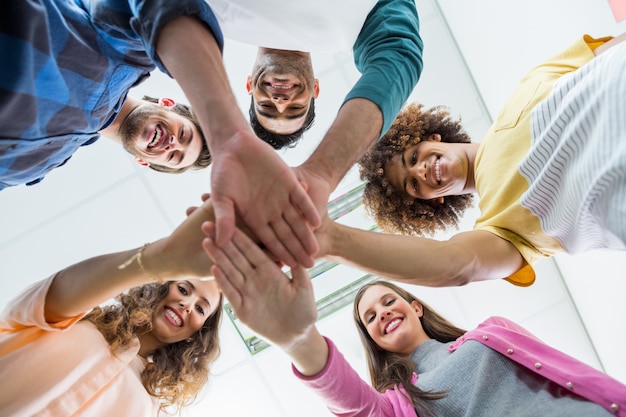 Squadra di dirigenti sorridenti che formano stack di mano