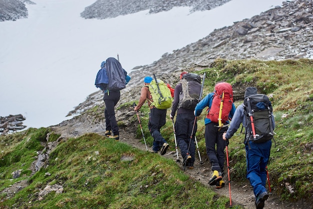 Squadra di escursionisti che camminano sul sentiero di montagna