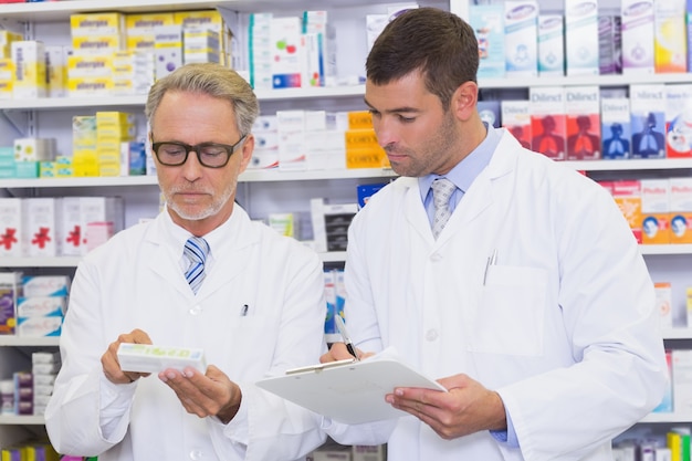 Squadra di farmacisti guardando scatola della medicina