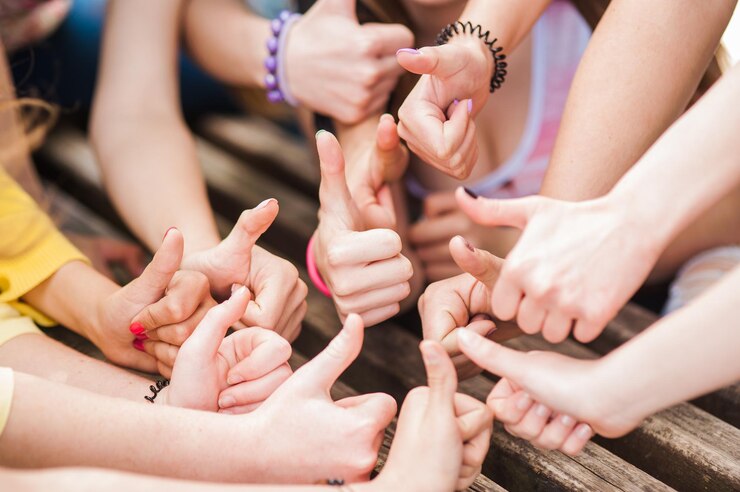 Squadra di giovani donne sedute insieme e tenendosi per mano