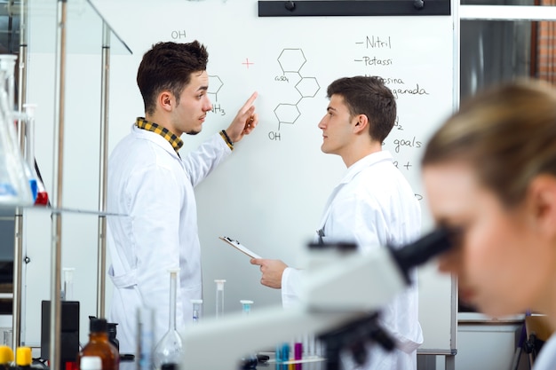 Squadra di giovani scienziati professionali che lavorano in laboratorio.