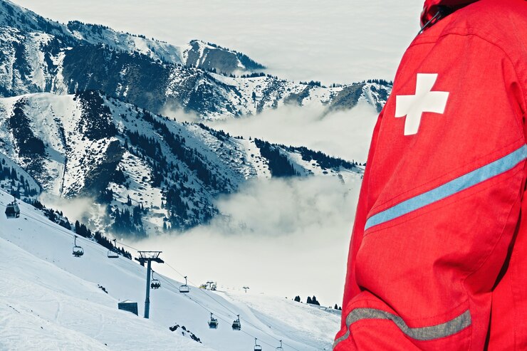 Squadra di soccorso di emergenza in uniforme rossa sulla stazione sciistica.