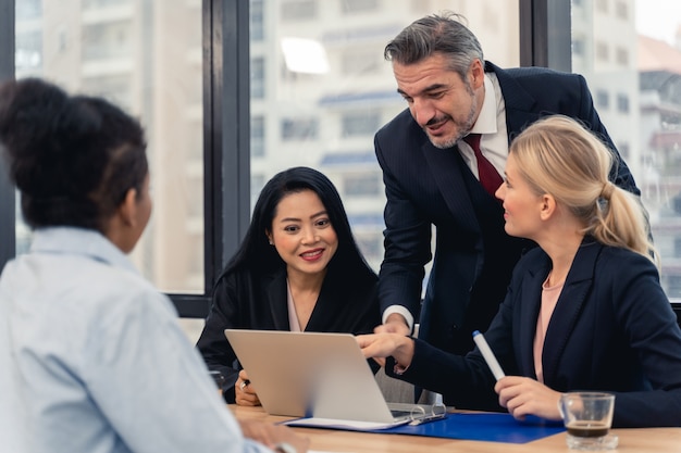 Squadra e responsabile di affari corporativi in una riunione. Giovane squadra di colleghe che fanno grande discussione di affari nell'ufficio moderno di coworking. Concetto della gente di lavoro di squadra