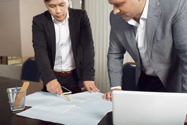 Squadra sicura di ingegneri che lavorano insieme in uno studio di architetto.