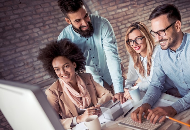 Squadra sorridente di uomini d'affari che lavorano insieme in compagnia