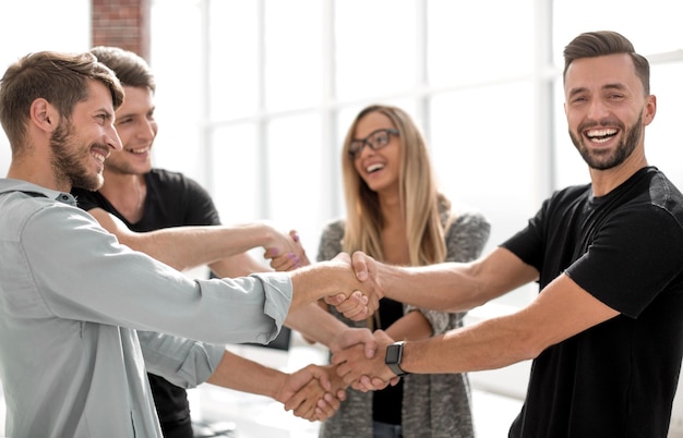 Squadra sorridente felice di affari che sta in fila all'ufficio