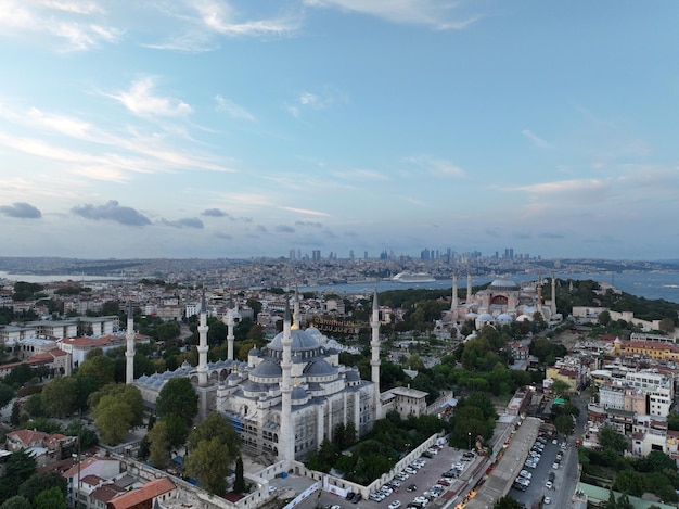 Stabilimento di un drone aereo in orbita di una Santa Grande Moschea di Hagia Sophia con il ponte del Bosforo e l'orizzonte della città con una bandiera sullo sfondo a Fatih Istanbul Turchia al tramonto