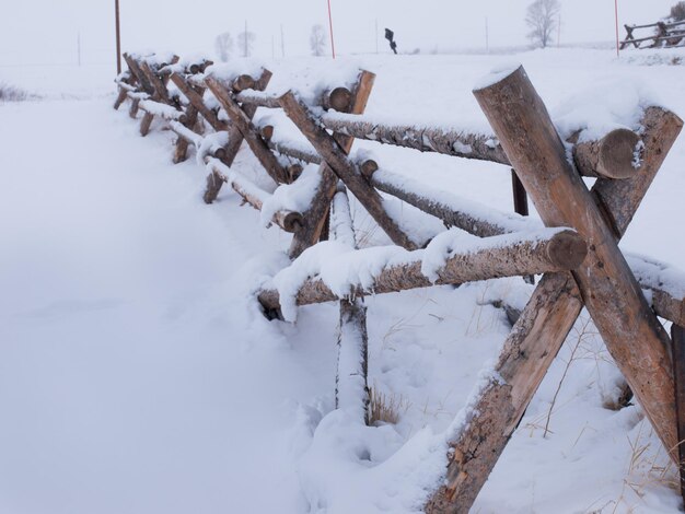 Staccionata in legno ricoperta di neve