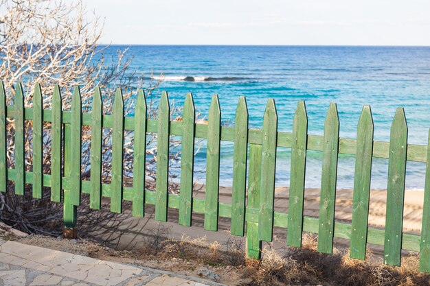 Staccionata in legno verde sulla spiaggia del mare