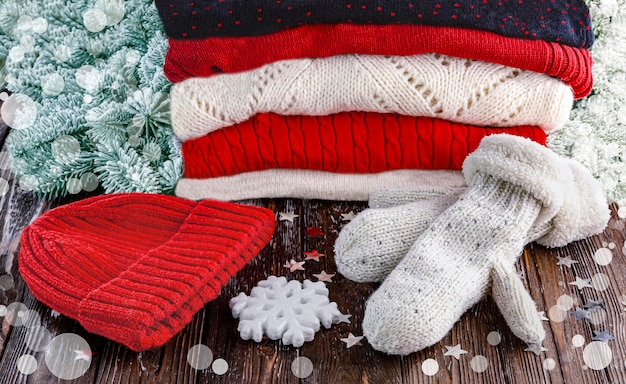 Stack di maglioni di lana invernali rossi e bianchi cappello rosso guanti di lana decorazione di Natale