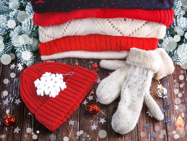 Stack di maglioni di lana invernali rossi e bianchi cappello rosso guanti di lana decorazione di Natale