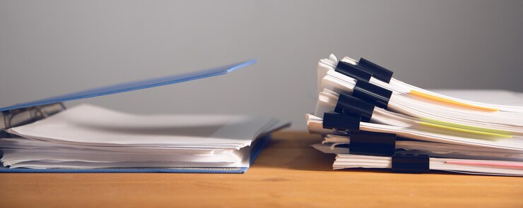 Photo stacks of many binders with files, folders on office desk