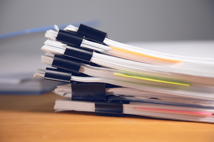 Photo stacks of many binders with files, folders on office desk