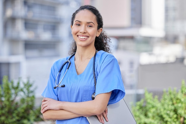 Stai ricevendo la migliore assistenza sanitaria Inquadratura di una giovane dottoressa in piedi con le braccia incrociate sullo sfondo di una città