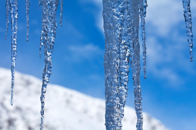 Stalattiti di ghiaccio davanti a una montagna innevata