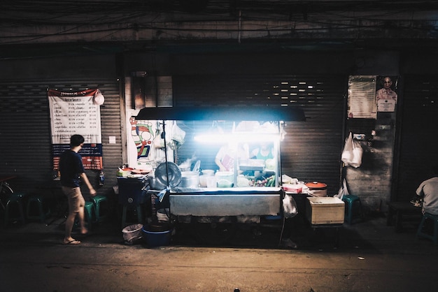 Stalla di cibo illuminata in strada di notte