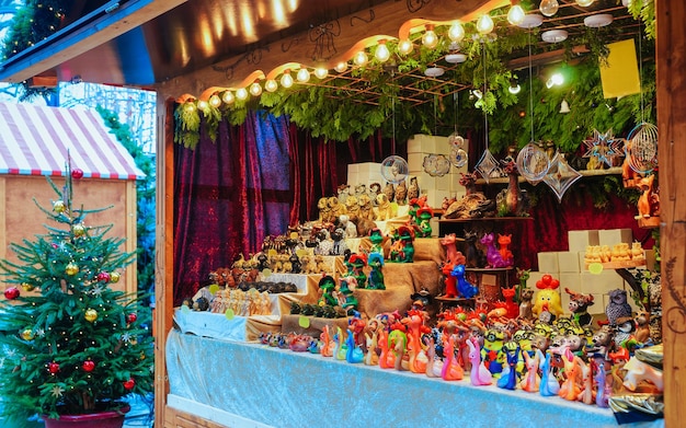 Stallo del mercatino di Natale presso la Chiesa commemorativa dell'Imperatore Guglielmo in inverno a Berlino, Germania. Decorazione della Fiera dell'Avvento e bancarelle con oggetti di artigianato sul Bazaar. Natale di strada tedesco e fiera delle vacanze