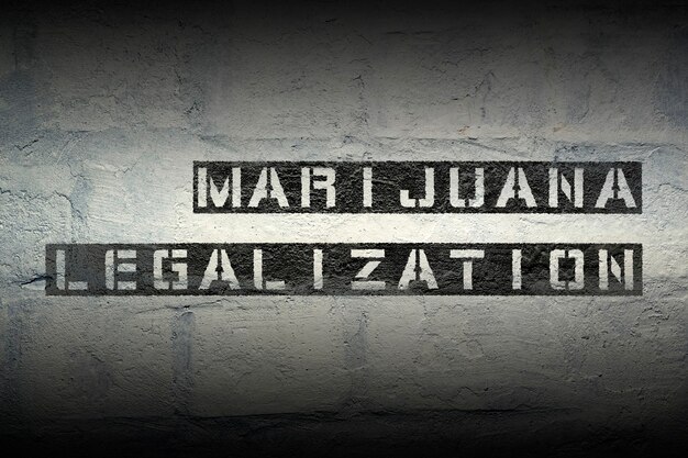 Stampa stencil di legalizzazione della marijuana sul muro di mattoni bianchi del grunge