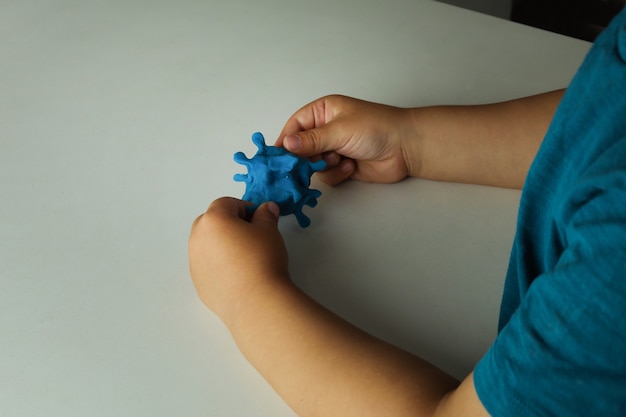 Stampaggio di bambini con plastilina coronavirus. Virus Covid-19 e bambini. Plastilina, pasta da gioco.