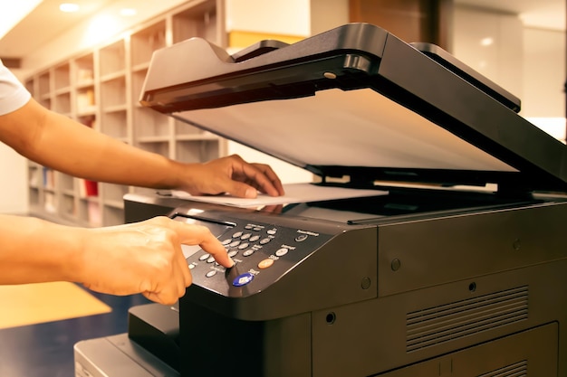 Stampante fotocopiatrice Primo piano ufficio uomo premere il pulsante di copia sul pannello per utilizzare la fotocopiatrice o la fotocopiatrice per la scansione di documenti stampando un foglio di carta e fotocopia xerox