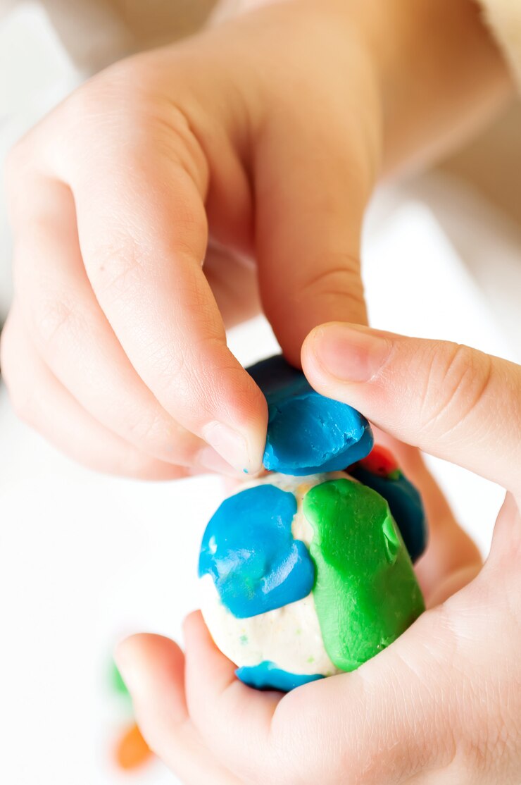 Stampi per bambini da plastilina sul tavolo, mani del bambino con la plastilina