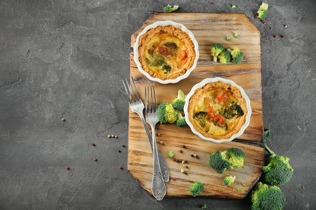 Stampini con gustosa quiche di broccoli su tavola di legno