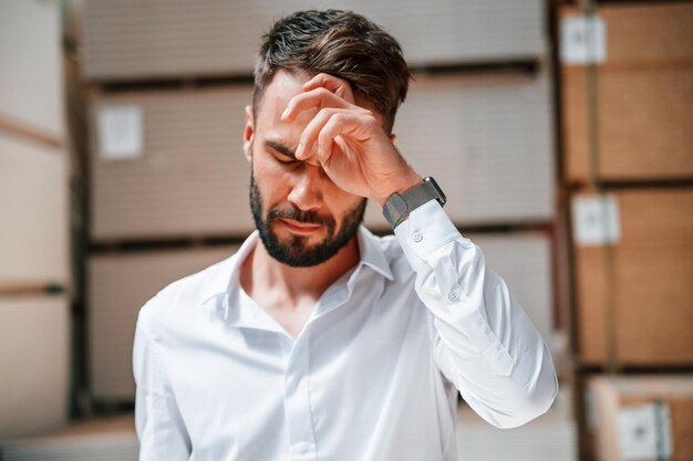 Stanco di sentirsi male L'addetto allo stoccaggio è nel magazzino con un sacco di prodotti