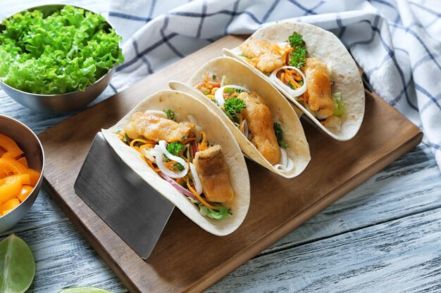 Stand con deliziosi tacos di pesce sul tavolo di legno