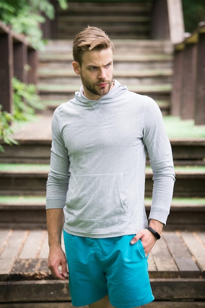 Stand uomo barbuto sulle scale all'aperto Sportivo sicuro in stile casual pronto per l'allenamento Allenamento all'aria aperta Futuro e successo Sport e fitness