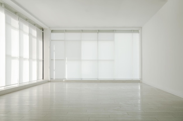 Stanza vuota con finestre panoramiche e pavimento in legno bianco