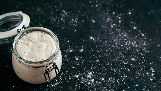 Starter di lievito di grano vaso di vetro con starter di lievito su sfondo scuro spazio di copia