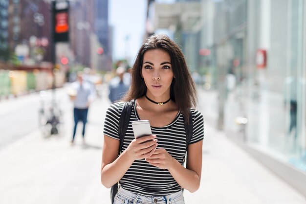 Stati Uniti d'America, New York City, giovane donna tenendo il cellulare a Manhattan