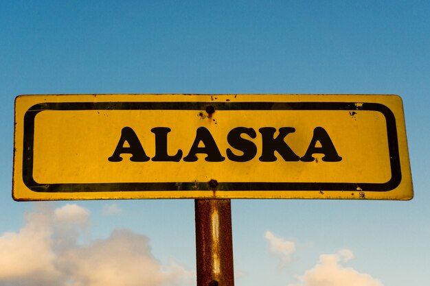 Stato dell'Alaska sul vecchio cartello giallo con cielo blu