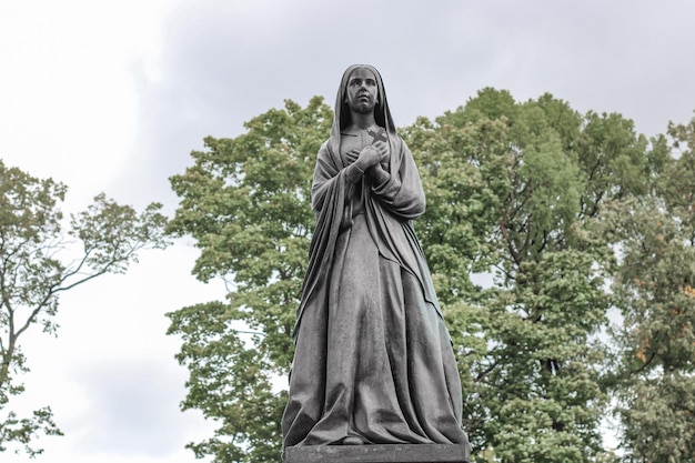 Statua antica inquietante con un'ala in un cimitero