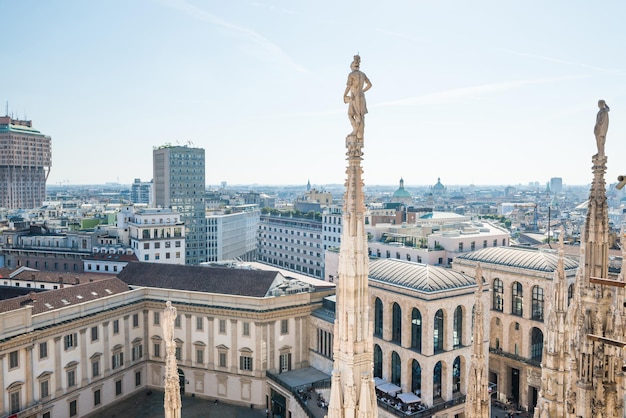 Statua bianca in cima al Duomo e vista sulla città di Milano