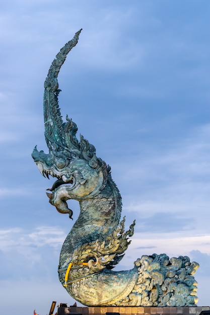 Statua del re di Naga con cielo nuvoloso sullo sfondo.