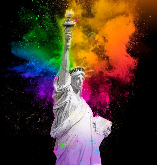 Statua della libertà con esplosione di polvere di vernice holi arcobaleno colorato isolata su sfondo nero