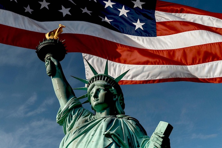Foto statua della libertà con la bandiera americana che ondeggia sullo sfondo