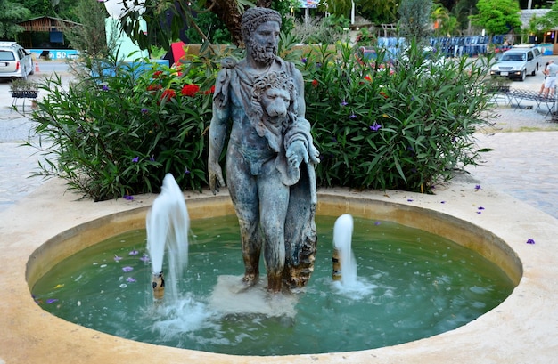 Statua della testa del leone e dell'uomo con la fontana al giardino