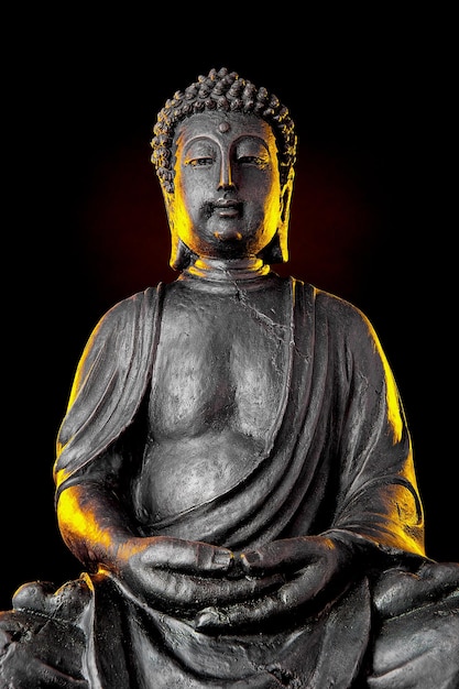 Statua di Buddha con bagliore su sfondo nero