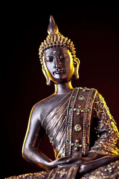 Statua di Buddha con bagliore su sfondo nero