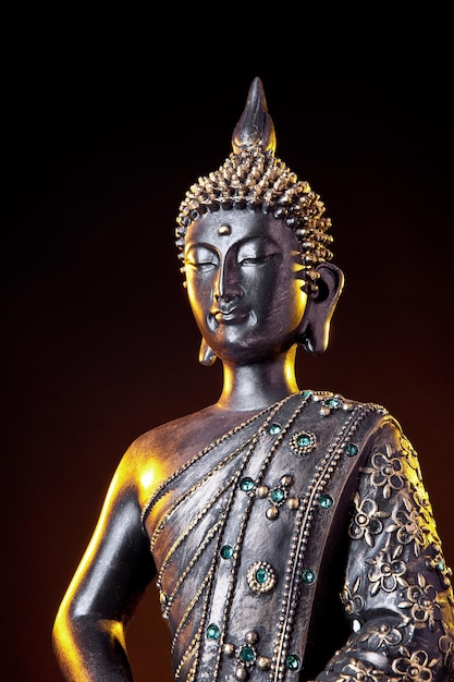 Statua di Buddha con bagliore su sfondo nero