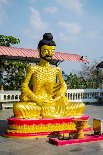 Statua di Buddha contro uno spazio blu della copia del cielo chiaro