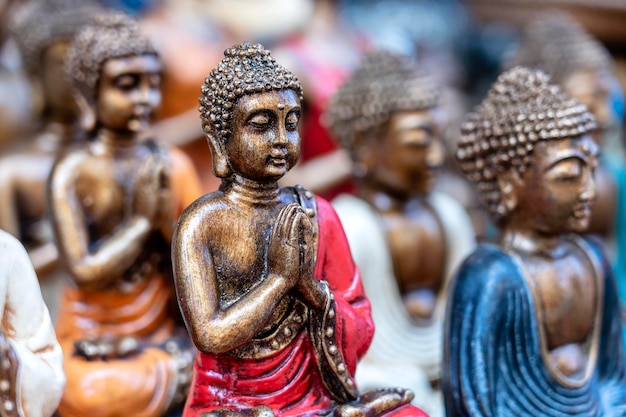 Statua di Buddha figure souvenir in esposizione per la vendita sul mercato di strada a Bali Indonesia Artigianato e negozio di souvenir da vicino