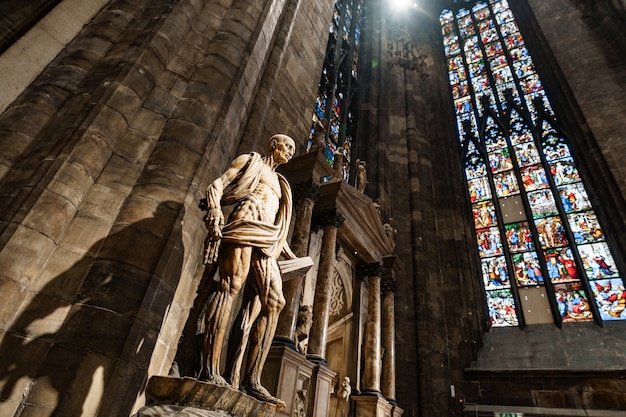 Statua di san bartolomeo con un libro su un piedistallo nel duomo italia milano